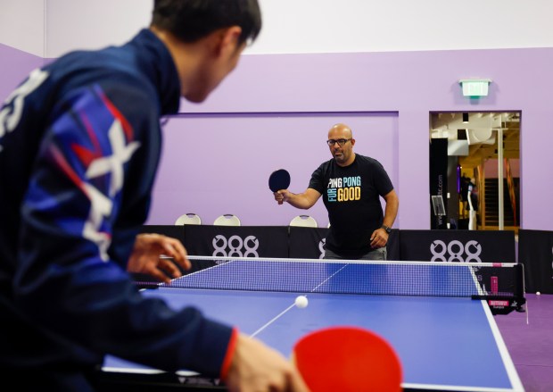Jake Tu, table tennis coach from Burlingame, left, plays with...