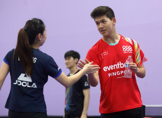 Olympic table tennis player Lily Zhang, left, high-fives Bosman Botha during practice at 888 Table Tennis in Burlingame, Calif., on Thursday, June 20, 2024. (Nhat V. Meyer/Bay Area News Group)