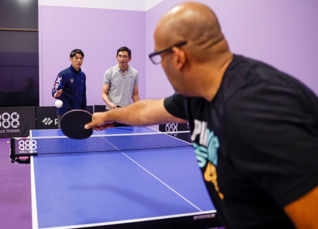 Jake Tu, table tennis coach from Burlingame, left, teaches Walter...