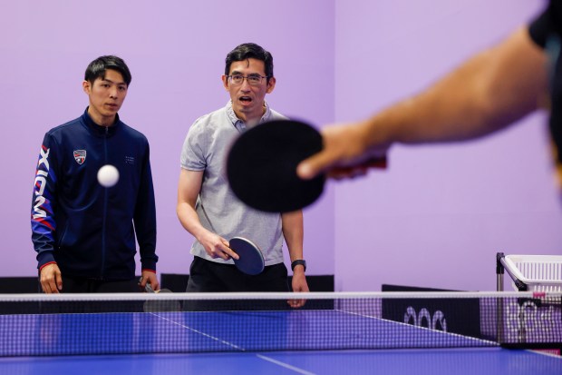 Jake Tu, table tennis coach from Burlingame, left, teaches Walter...