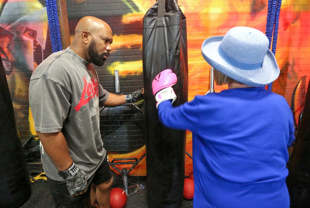 Marlon Ealy from Rock Steady Boxing works in a boxing workout with client Cathy Walsh at OC Fit Sky Park location in Irvine.