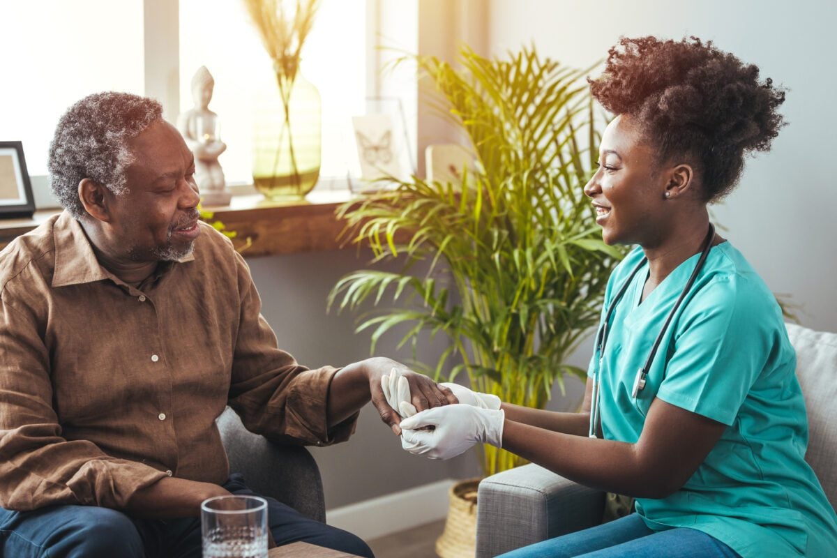 man holding hands with nurse with Parkinson's Disease