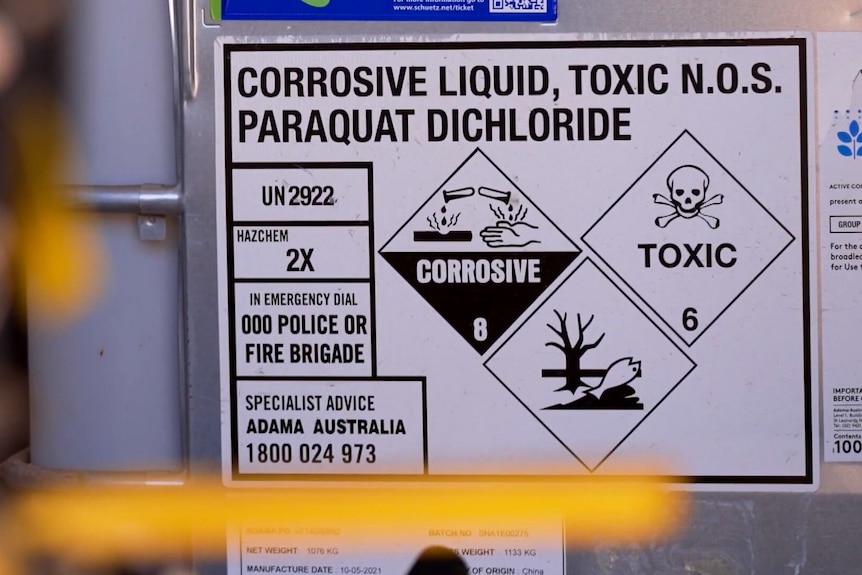 A label on a plastic tub reads CORROSIVE LIQUID, TOXIC N.O.S. PARAQUAT DICHLORIDE