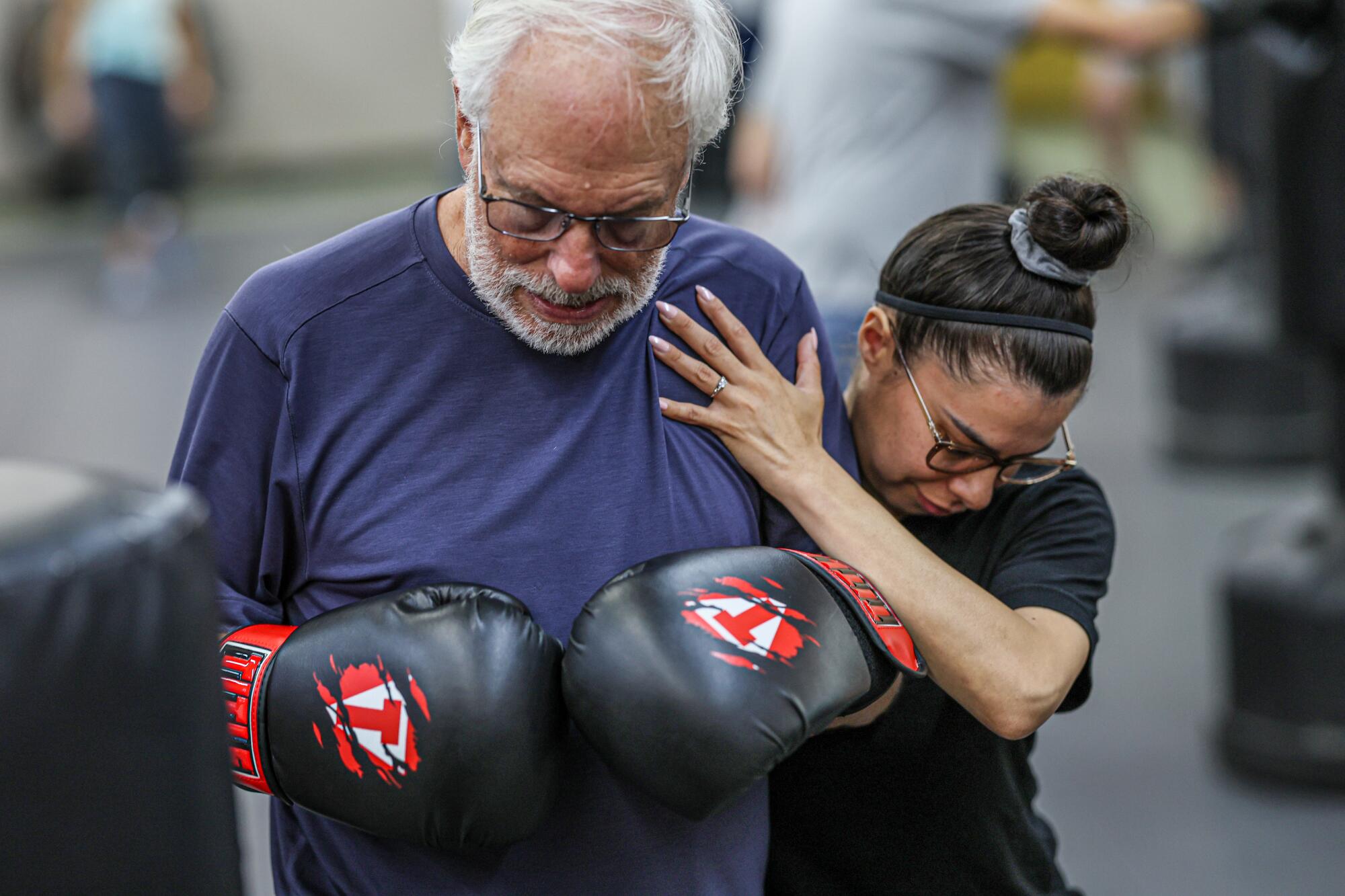 Alan Shankin is assisted by a physical therapy student Desiree Alvarado as he participates in a boxing class