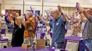 Participants at last year’s symposium engage in guided stretching exercises.